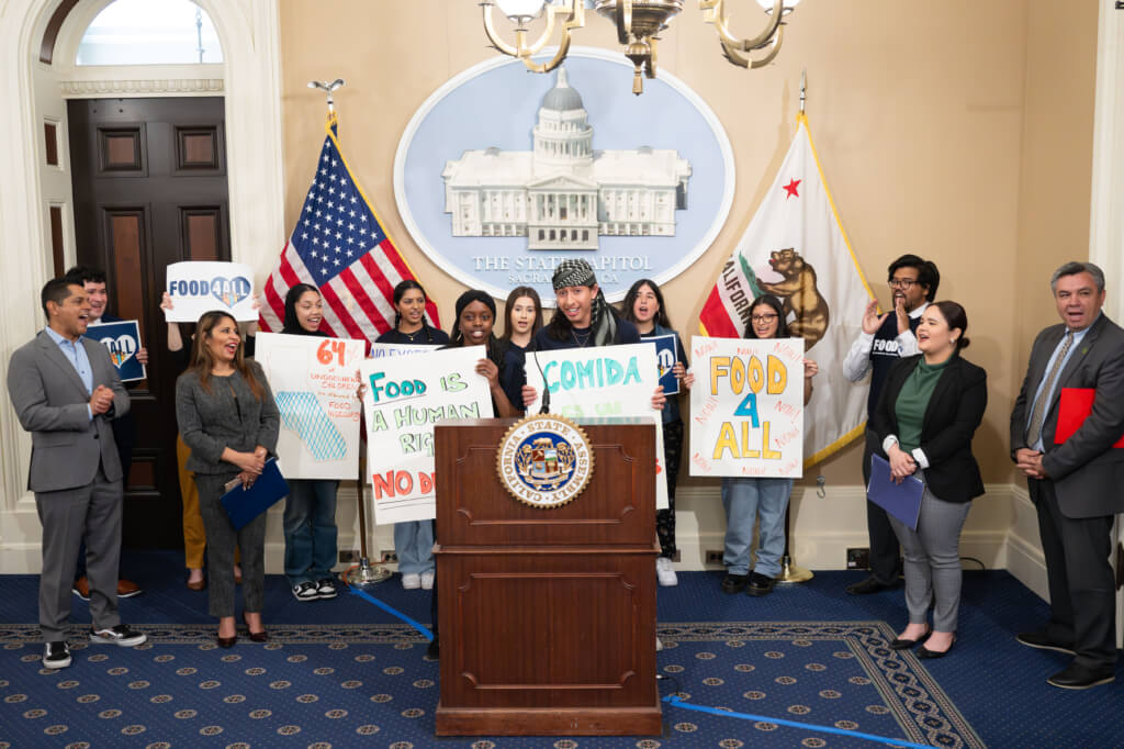 Food4All youth advocates lead legislators and the Food4All coalition in a chant at the state capitol